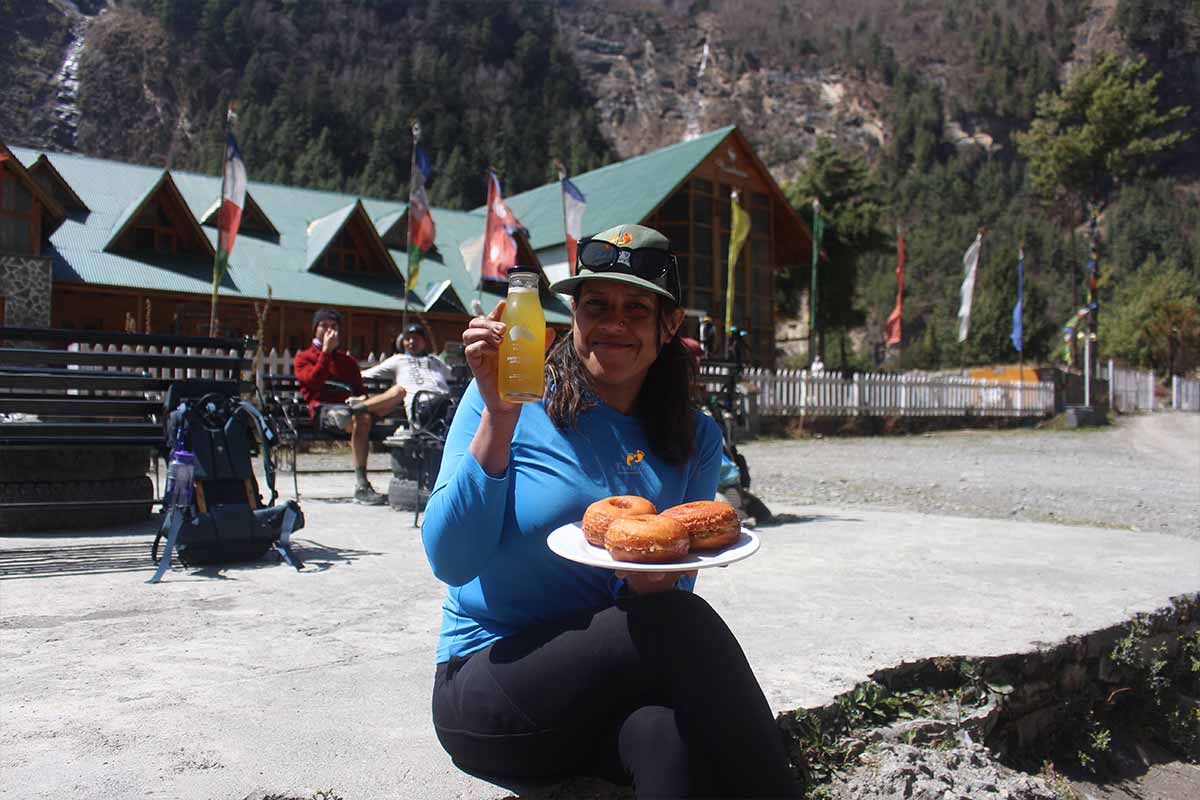 A female having juice and donuts at Bratang Village on the way to Pisang